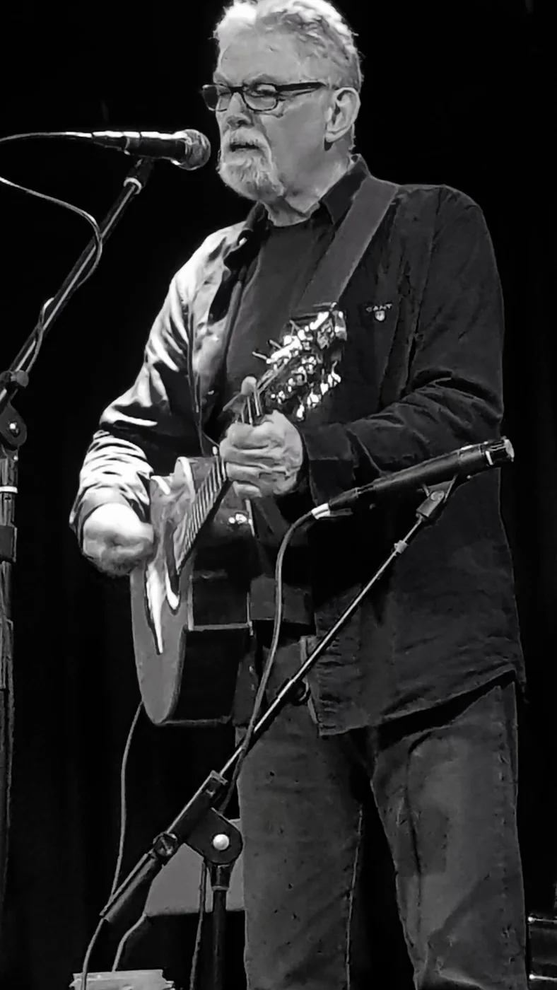 Black-and-white portrait of John Richards performing with bouzouki